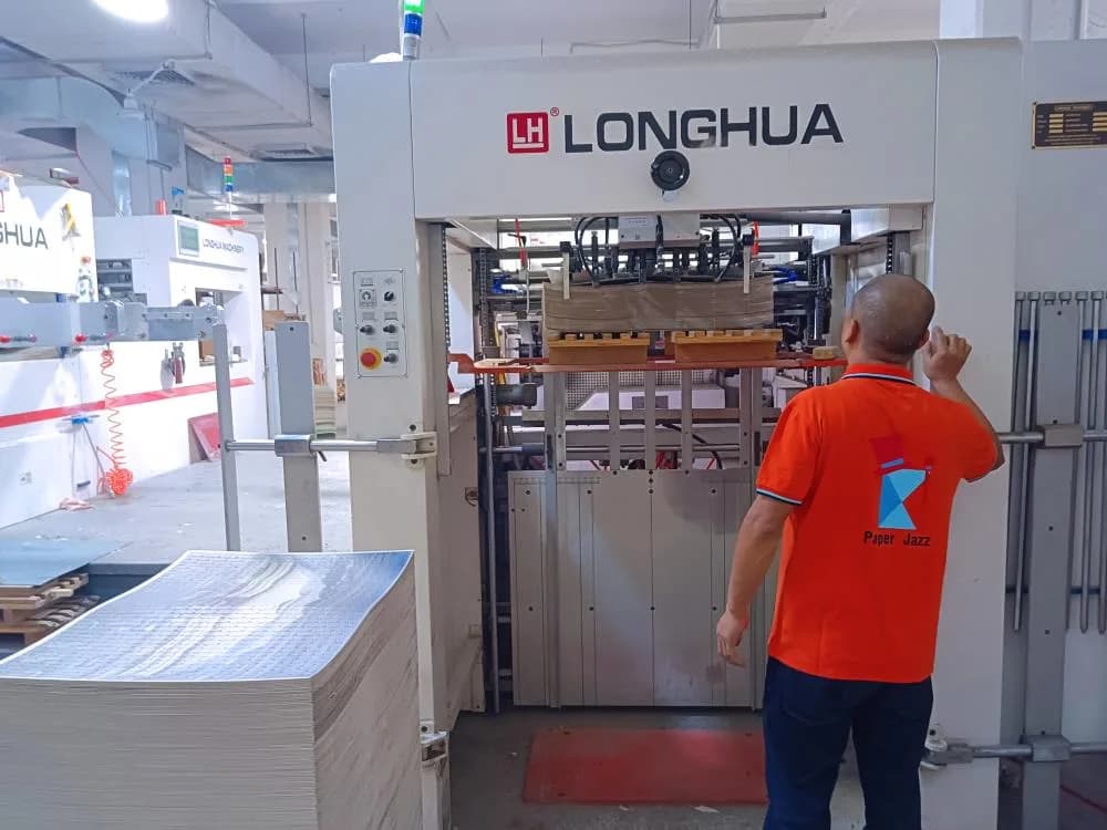 Operator beside die-cutting equipment at the Charmer production site