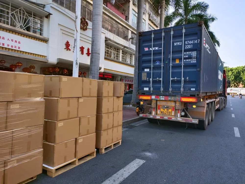 Stacked cartons near a container vehicle at the company site